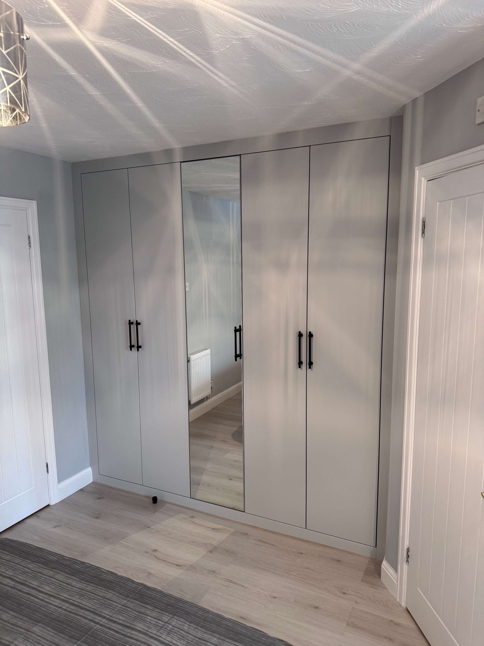 built-in-wardrobe-with-black-handles-mirror-door