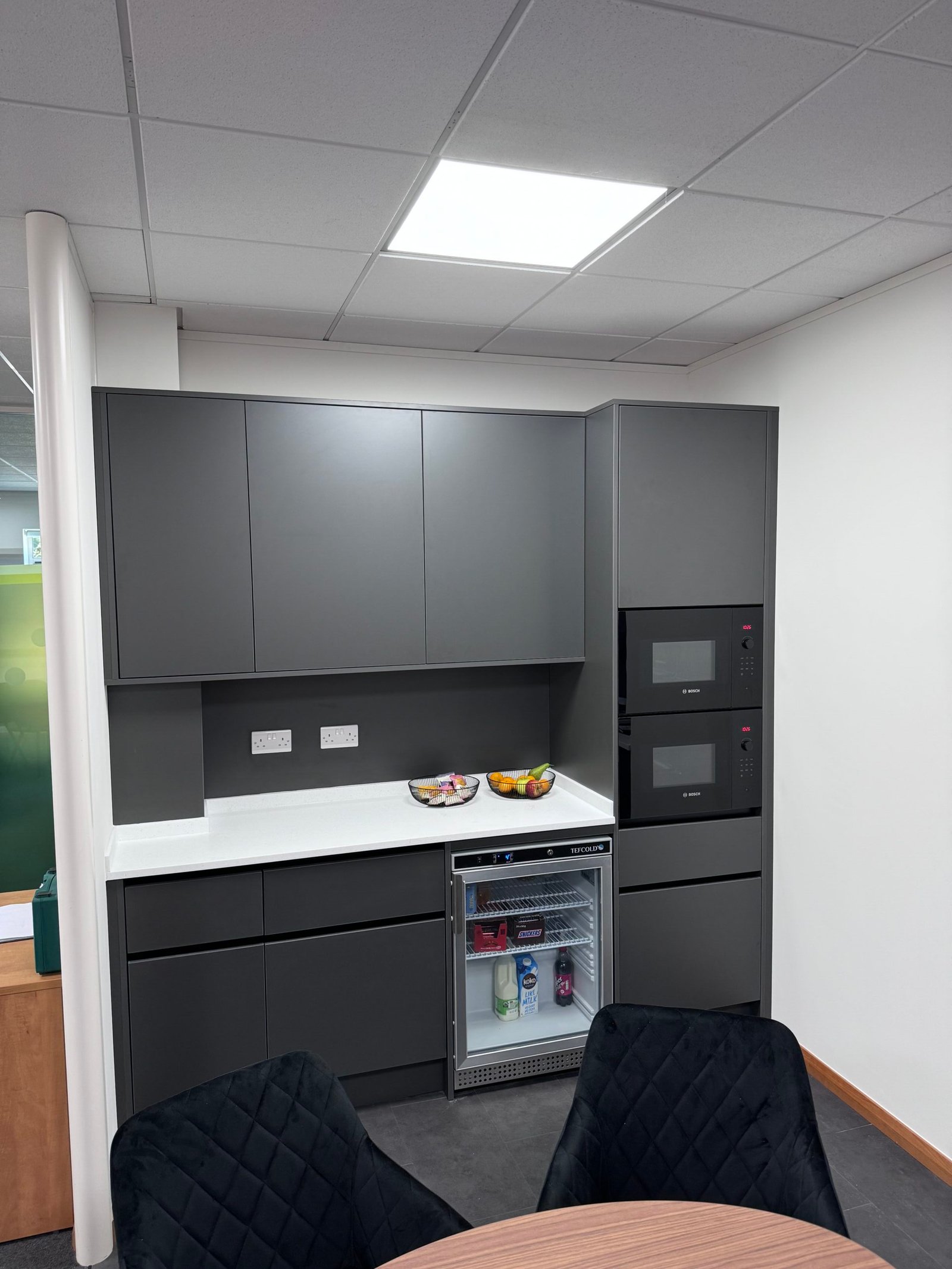 dark-grey-handless-cupboard-with-white-countertop
